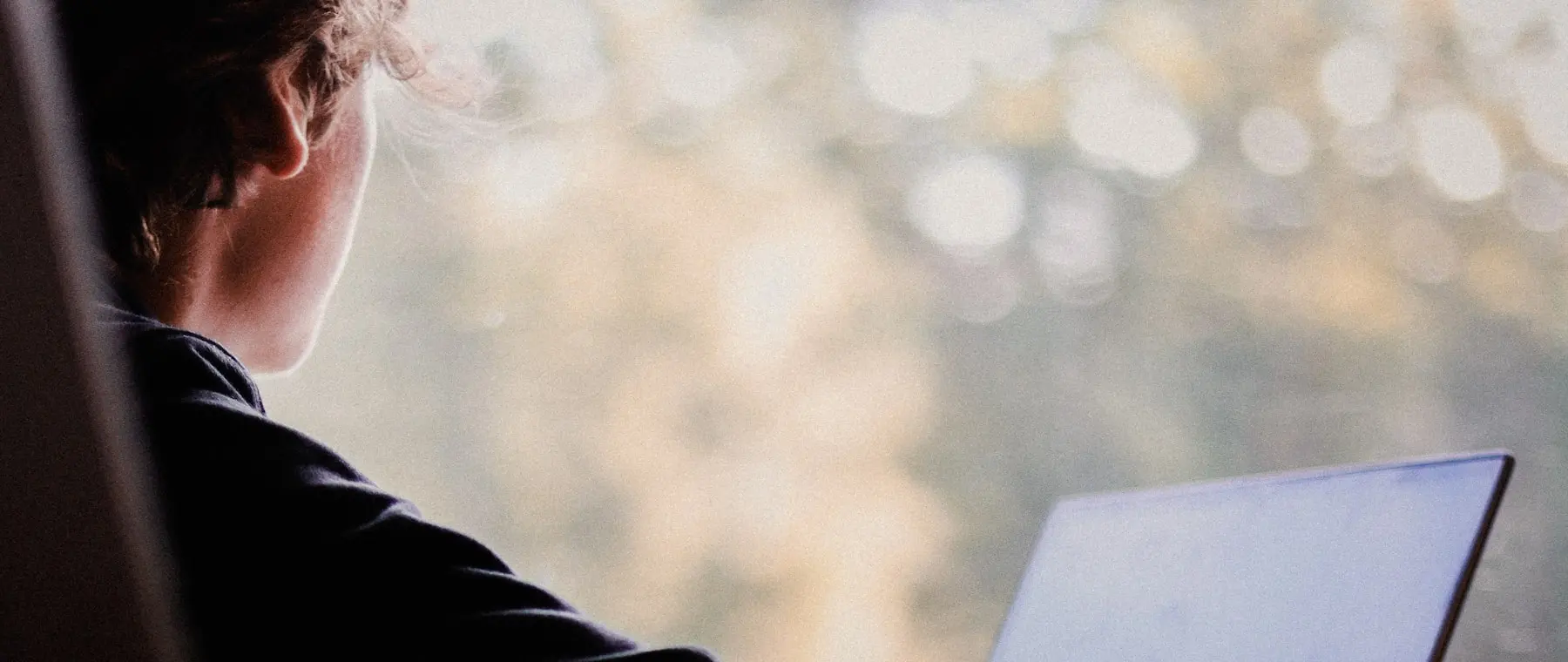 A person working at a laptop, seen from behind